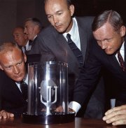 Buzz Aldrin, Michael Collins & Neil Armstrong looking at a sample of moon rock that they had brought back to earth with them