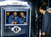 Armstrong, Collins & Aldrin in their quarantine trailer on board USS Hornet, being greeted by President Richard Nixon