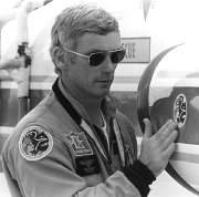 Gene Cernan in 1972 sticking an Apollo 17 emblem on his NASA T-38 before leaving for the Apollo 17 mission.  Patches from all 3 of his missions are on his jacket.