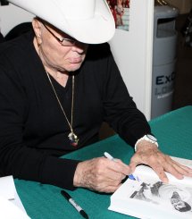 Tony Curtis signing a copy of his autobiography at London Expo in May 2009