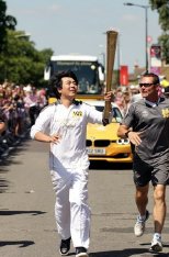 Lang Lang carrying the 2012 Olympic torch through Hornchurch