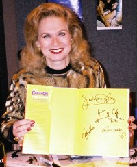 Valerie Leon holding signed 'Carry On' book