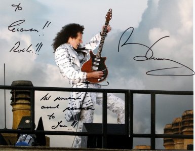 Brian May signed photo. It shows him playing the National Anthem on the roof of Buckingham Palace in 2002