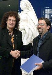 Brian May hands in his PhD thesis to Professor Paul Nandra at Imperial College