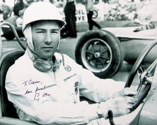 Photograph signed by Sir Stirling Moss showing him in his Maserati before the 1954 Belgian Grand Prix in which he finished third