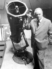 Sir Patrick Moore with his reflector telescope in his observatory at Farthings