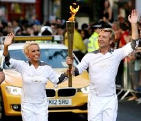 Jayne Torvill and Christopher Dean carry the Olympic Torch through Nottingham in 2012