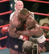 Mike Tyson bites off a piece of Evander Holyfield's ear during their fight in 1997