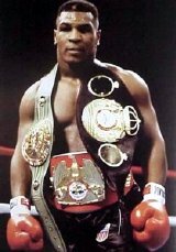 Mike Tyson in 1987 with his three heavyweight title belts