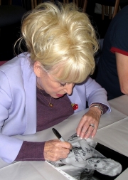 Barbara Windsor signing a photograph