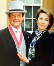 Roger Moore with his daughter Debbie after receiving his CBE in 1999